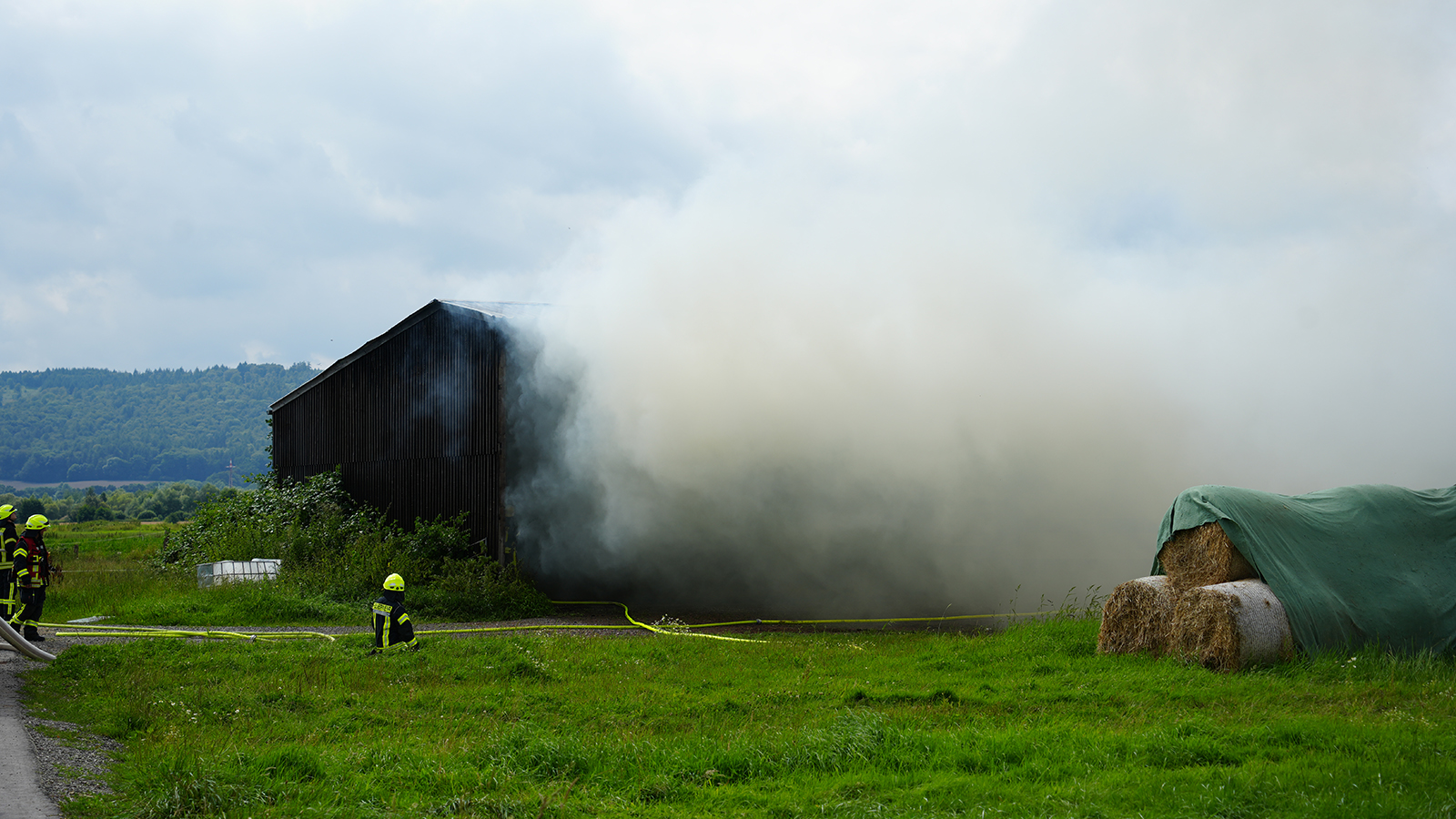 Landwirtschaftliche Fahrzeuge und Strohballen in Flammen: Großeinsatz für die Feuerwehr 